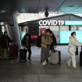 Masked passengers arriving from China pass by a Covid-19 testing center at an airport in South Korea.