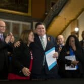 Illinois Gov. J.B. Pritzker celebrates after signing a bill to ban military-style firearms.