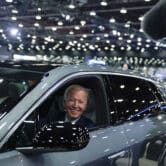 Joe Biden drives a car through the showroom during the Detroit Auto Show.