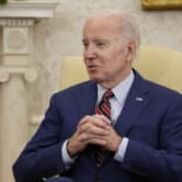 Joe Biden folds his hands during a meeting in the Oval Office of the White House.