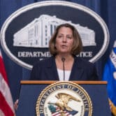 Lisa Monaco speaks behind a Justice Department lectern during a news conference.