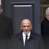 Nadhim Zahawi exits a building in London wearing a suit.