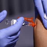 A patient receives a flu vaccine at a center in California.