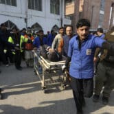 People transport a person injured during a suicide bombing in Pakistan.