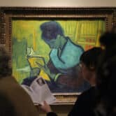 Visitors walk past the painting "The Novel Reader" by Vincent van Gogh in a museum in Detroit.