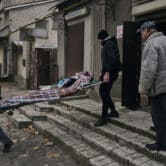 Local residents carry the body of a Ukrainian killed by Russian shelling.