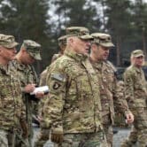 Mark Milley walks with U.S. Army leaders at a military training area in Germany.