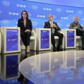 Five people sit on stage during a World Economic Forum panel discussion in Davos, Switzerland.
