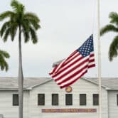 A flag flies at half-staff in front of a Marine Corps building at the Guantanamo Bay Naval Base.