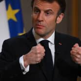 Emmanuel Macron gestures during a speech in front of the Flag of Europe.