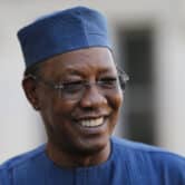 Idriss Deby Itno smiles while wearing glasses and a blue hat.