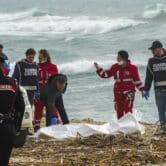 A body is recovered from a beach in southern Italy after a migrant boat broke apart in rough seas.