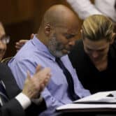 Lamar Johnson and his attorneys react while sitting at a table in a courtroom after his murder conviction is vacated.
