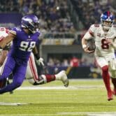 The quarterback for the New York Giants runs in a football game against the Minnesota Vikings.