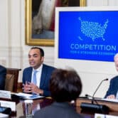 Pete Buttigieg, Rohit Chopra and Joe Biden participate in a meeting in the East Room of the White House.