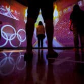 Visitors watch a simulation during the opening day of the U.S. Olympic and Paralympic Museum.