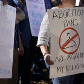 Abortion-rights supporters carry signs during a demonstration in Clayton, Missouri.