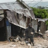 A man stands outside his house, which was damaged by Cyclone Freddy, in Blantyre, Malawi.