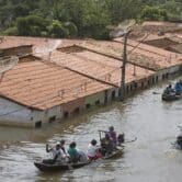 People travel by boat in a flooded street in Brazil.