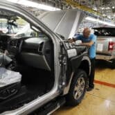 An assemblyman works on a Ford F-150 truck.