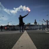 A protester uses a flare in Lyon, France.