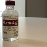 A vial of Humalog insulin sits on a table.