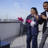 Janette OK and Imani Carrier gesture while using a smartphone to record a video on a rooftop in Washington.