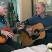 Lynda Bluestein and her husband Paul play guitars in their living room.