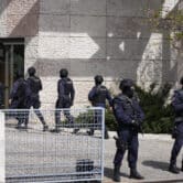 Ten police officers stand near an entrance to an Ismaili Muslim center in Portugal.