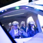Four people test a virtual reality flight simulator.