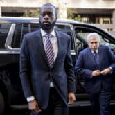 "Pras" Michel and his attorney David Kenner walk away from a black SUV in New York.