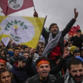 Pro-Kurdish Peoples' Democratic Party supporters gather and hold flags during Newroz celebrations in Turkey.