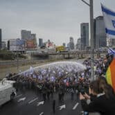 Israeli police use a water cannon to disperse Israelis blocking a freeway during a protest.