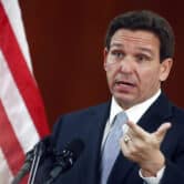 Ron DeSantis gestures while answering questions at a press conference.
