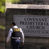 A police officer walks by a sign for The Covenant School in Nashville, Tennessee.