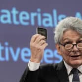 Thierry Breton holds up raw materials during a news conference.
