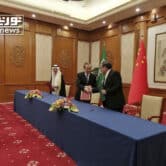 Wang Yi and Ali Shamkhani shake hands while Musaad bin Mohammed al-Aiban watches.