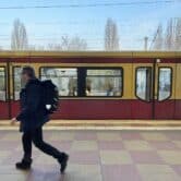 A passenger walks by a train at a station in Berlin.