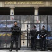 Police officers guard the entrance of the French Constitutional Council in Paris.