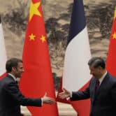 French President Emmanuel Macron shakes hands with Chinese President Xi Jinping.