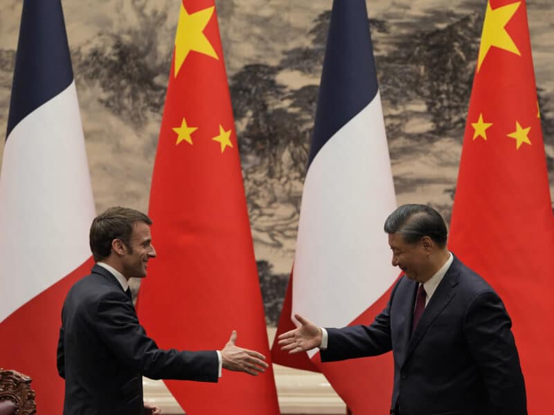 French President Emmanuel Macron shakes hands with Chinese President Xi Jinping.