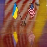 The Ukrainian and American flags are displayed on a wood table.