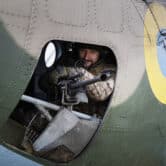 A Ukrainian serviceman holds a mounted machine gun in a combat helicopter.