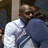 Andrew Gillum hugs Sharon Lettman-Hicks as several people stand around outside a Florida courthouse.