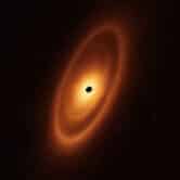 orange rings around a black dot in space