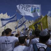 A group of Israelis waves flags during a Jerusalem Day march in front of the Damascus Gate.