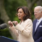 Kamala Harris gestures while speaking at an event in the Rose Garden, with Joe Biden behind her.