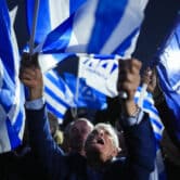 Supporters of Greek Prime Minister Kyriakos Mitsotakis celebrate in Athens.
