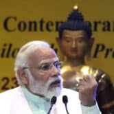 Narendra Modi raises his left fist while speaking at an event.