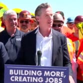 Gavin Newsom speaks with a group of workers.